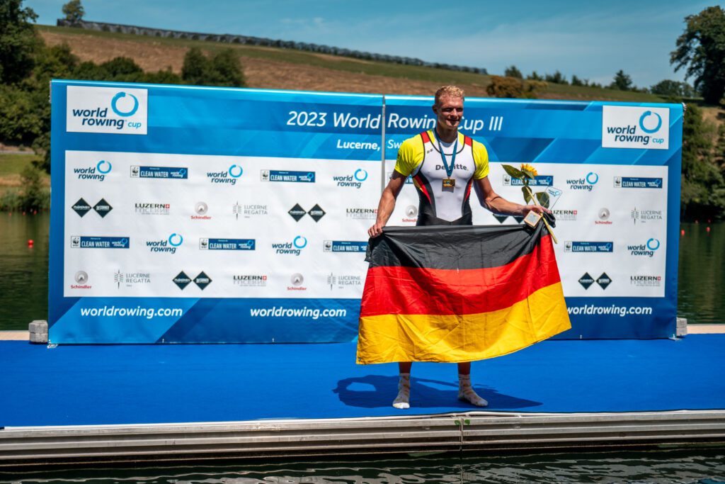 Olliver Zeidler, Germany's men's single sculler GER M1x, on the World Rowing Cup podium, by Row360.